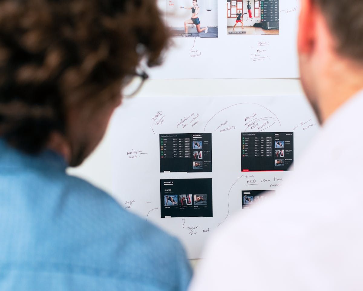 Two professionals brainstorming software development on a whiteboard